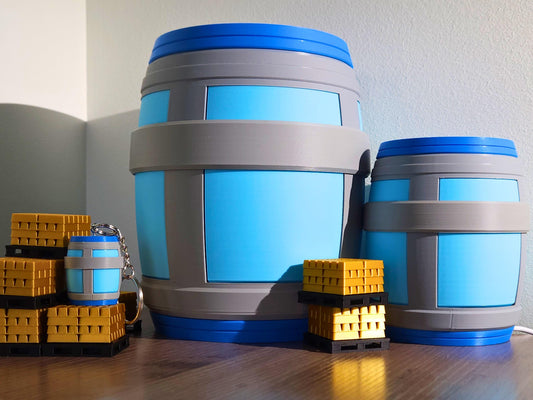 A picture of chug jug lamps from the video game fortnite. one large size, one mini, and one keychain size, positioned around some gold bars.