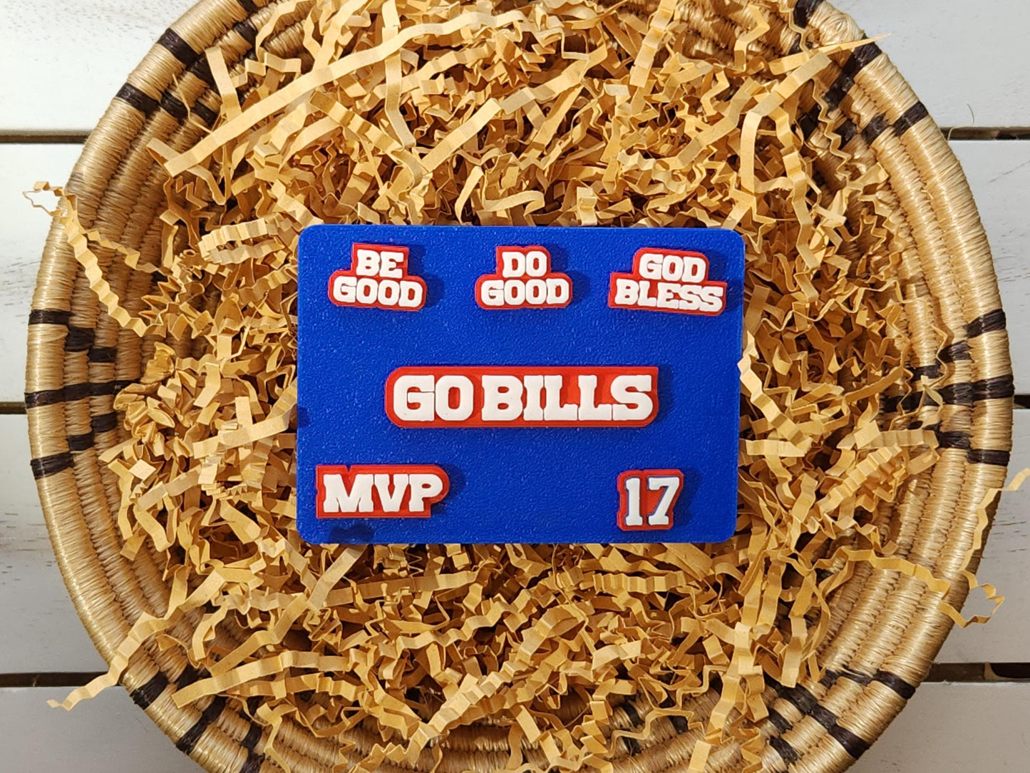 Buffalo Bills 6-pin set pictured in a basket on a wooden background. Pins pictured are white on a red background and say Do Good Be Good God Bless Go Bills #17 MVP in honor of Buffalo Bills Josh Allen's MVP performance.