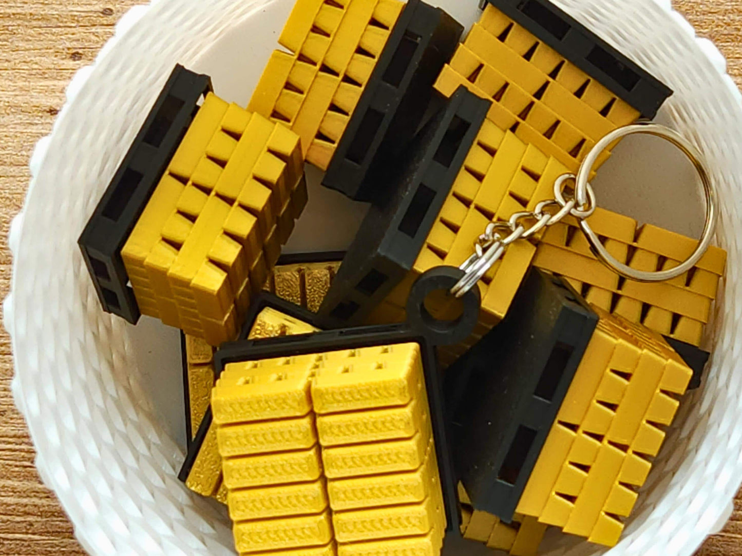 A close up picture of a basket full of gold bar keychains from Fortnite. The top has a mechanical clicker that can be used for anti-stress or fidgeting.
