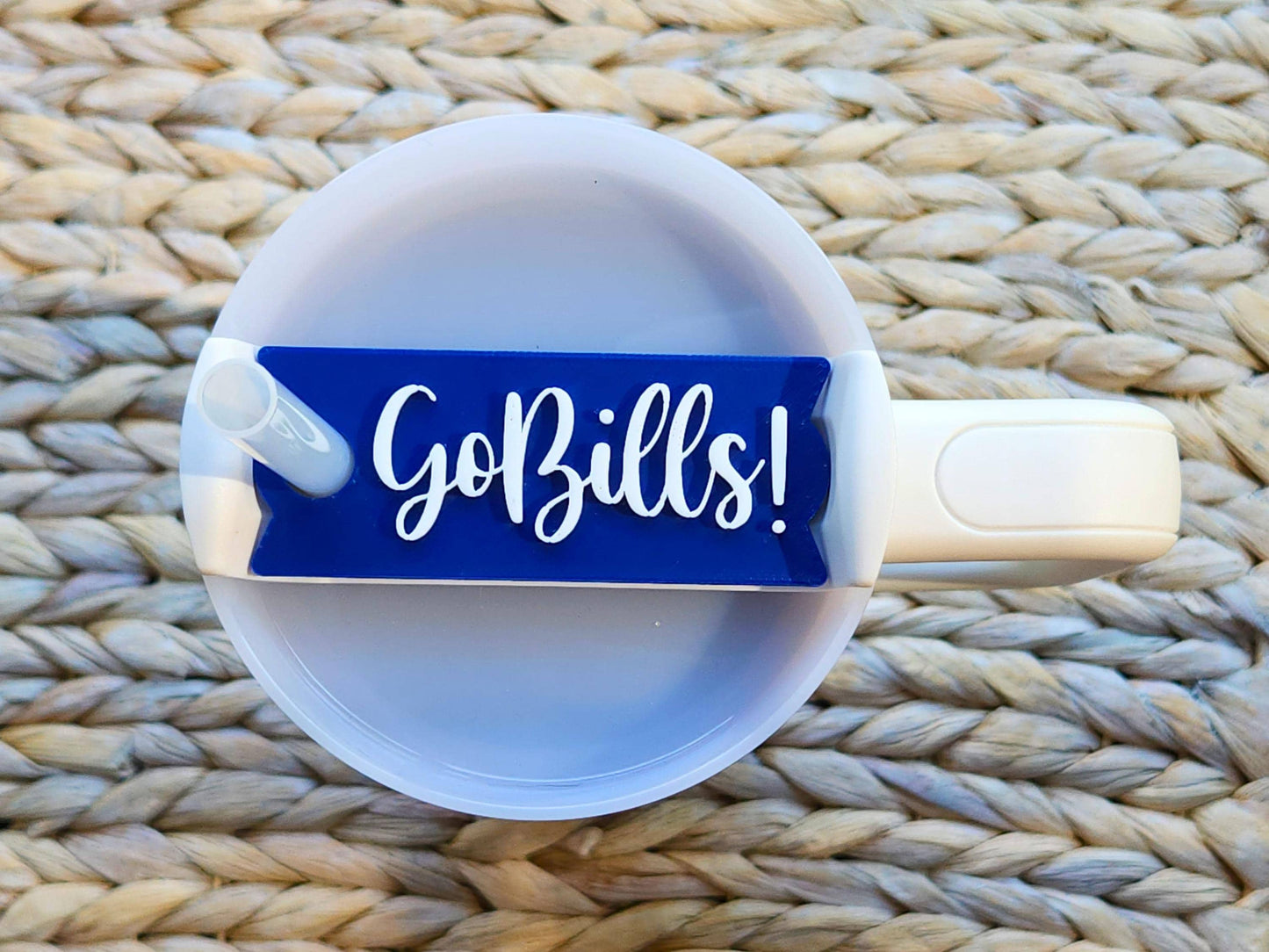 Go Bills! Stanley cup topper in bold white script on a blue background, sitting on top of a cream-colored Stanley tumbler with straw.