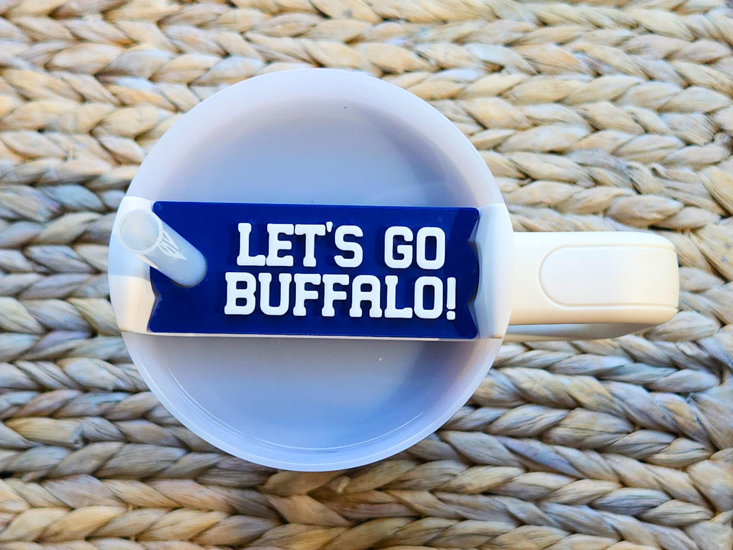 Blue ‘Let’s Go Buffalo!’ Stanley cup topper placed on a white Stanley tumbler with a straw, showing how the lid fits securely and adds Buffalo football spirit.