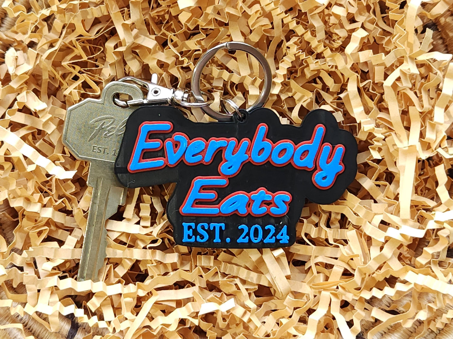 Buffalo Bills inspired "Everybody Eats" Est. 2024 keychain nestled in kraft paper gift box filler – perfect gift for fans, teams, and sports lovers