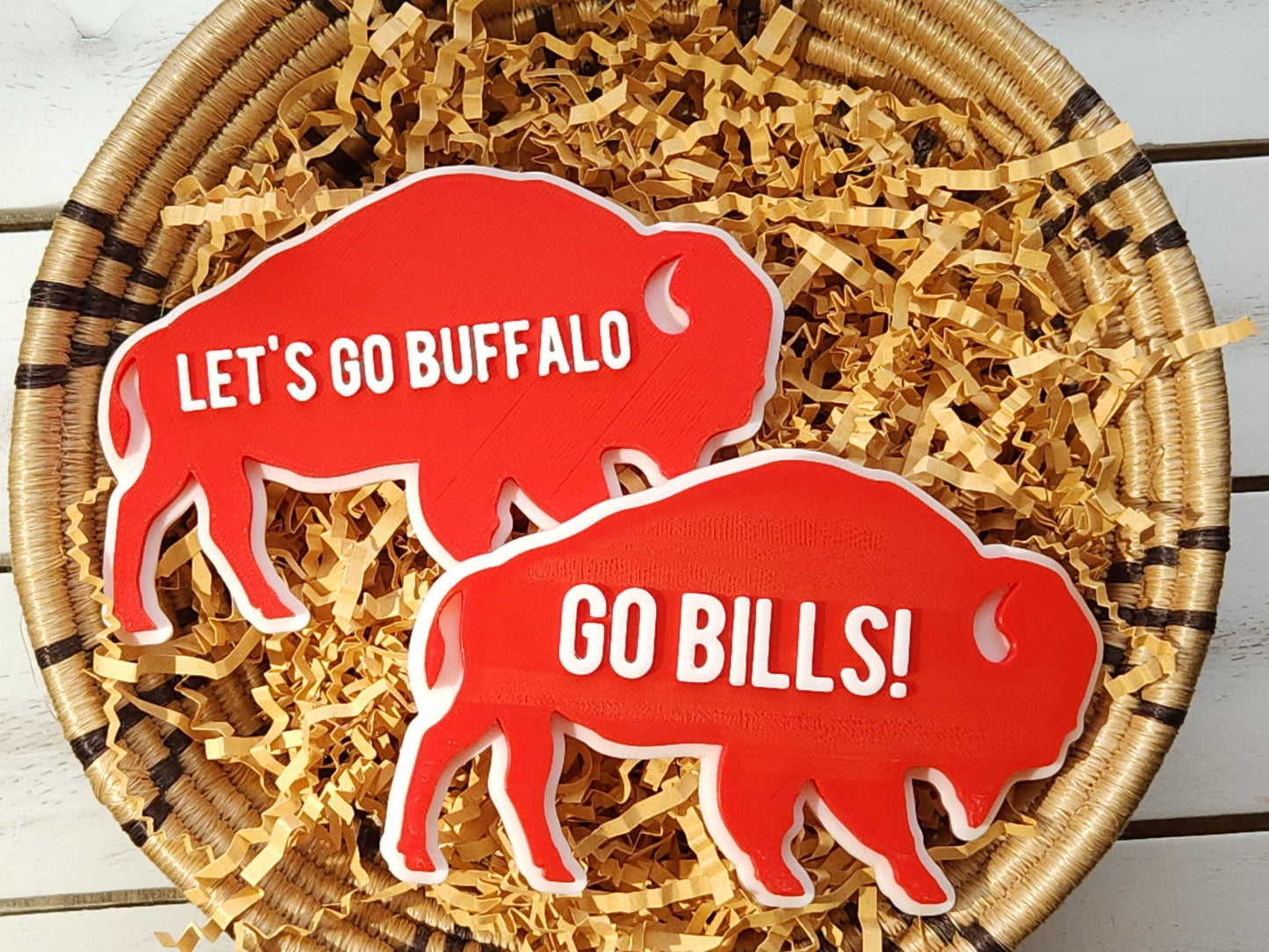 2 Retro Buffalo Bills magnets pictured in a basket. One says Let's Go Buffalo and the other says Go Bills in raised white letters on a bright red background.