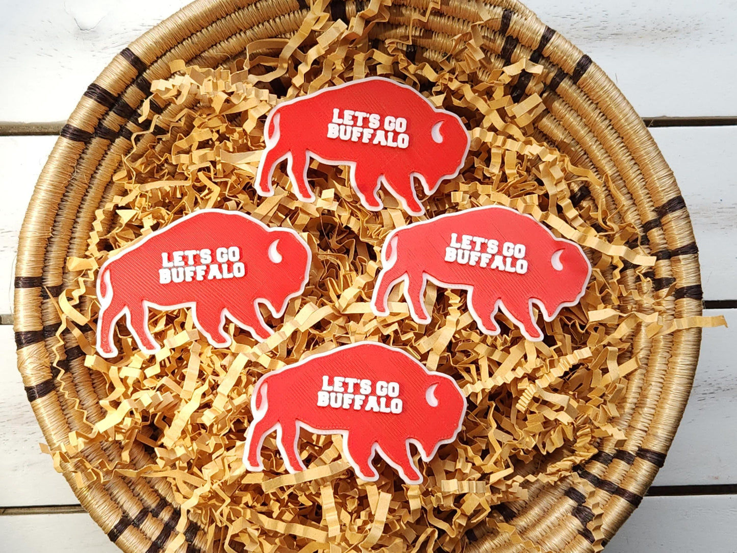 Several red Lets Go Buffalo magnets stacked in a bowl.