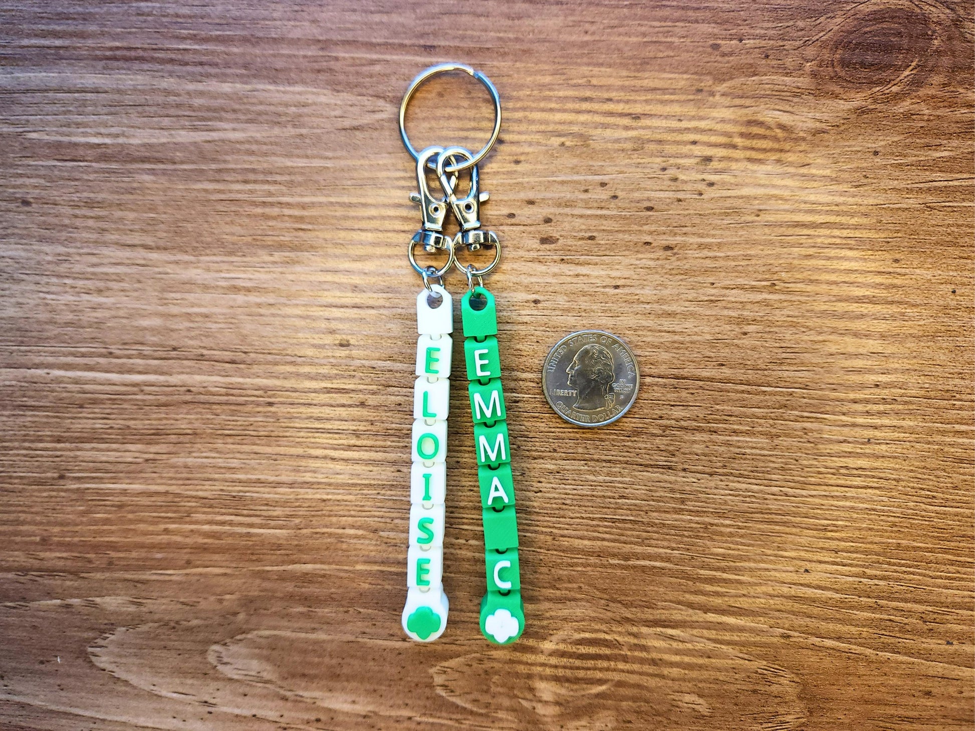 Two keychains shown next to a quarter for size reference.