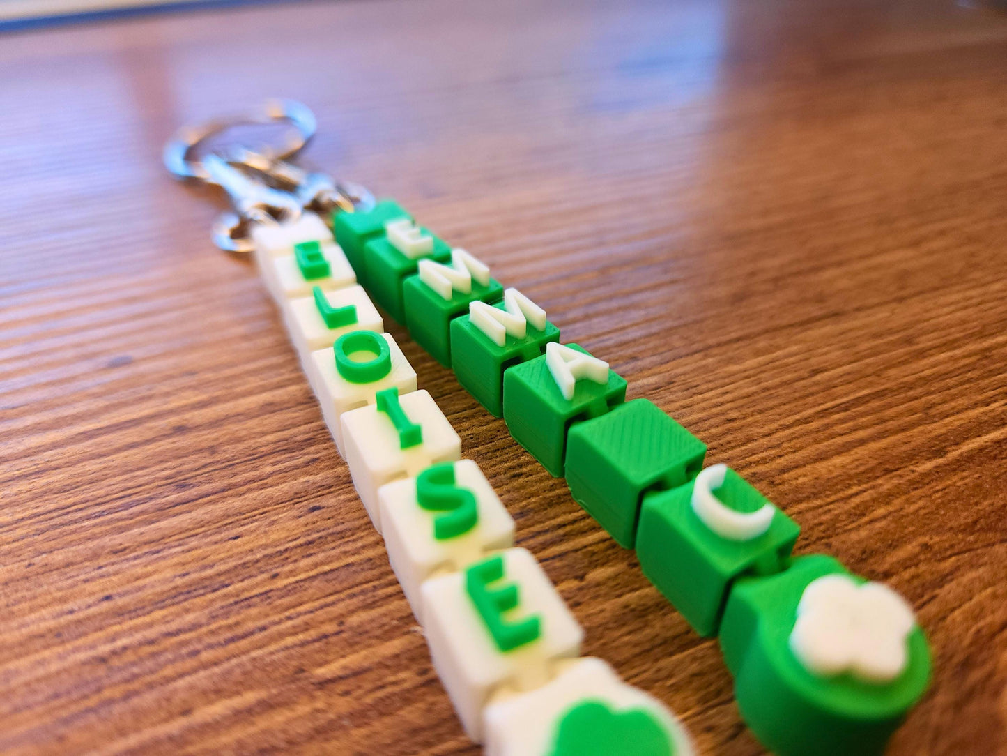 Close up of two green and white keychains, perfect for girl scouts.