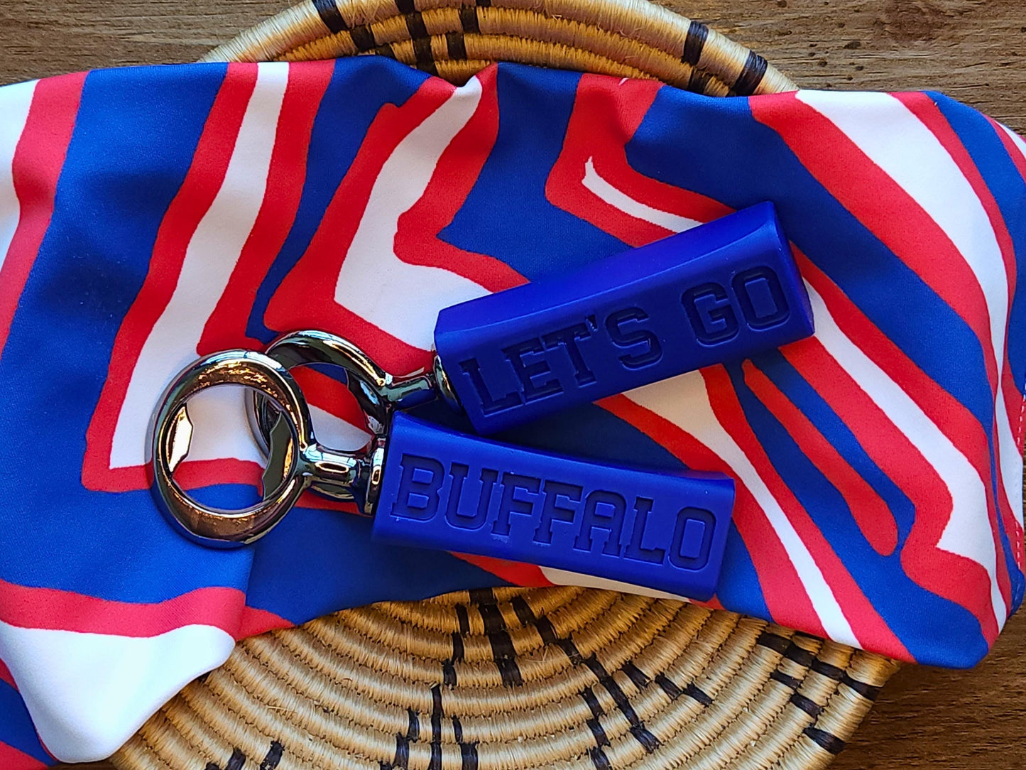 The same bottle openers on top of a red, white, and blue sports-themed fabric, emphasizing their Buffalo team spirit.
