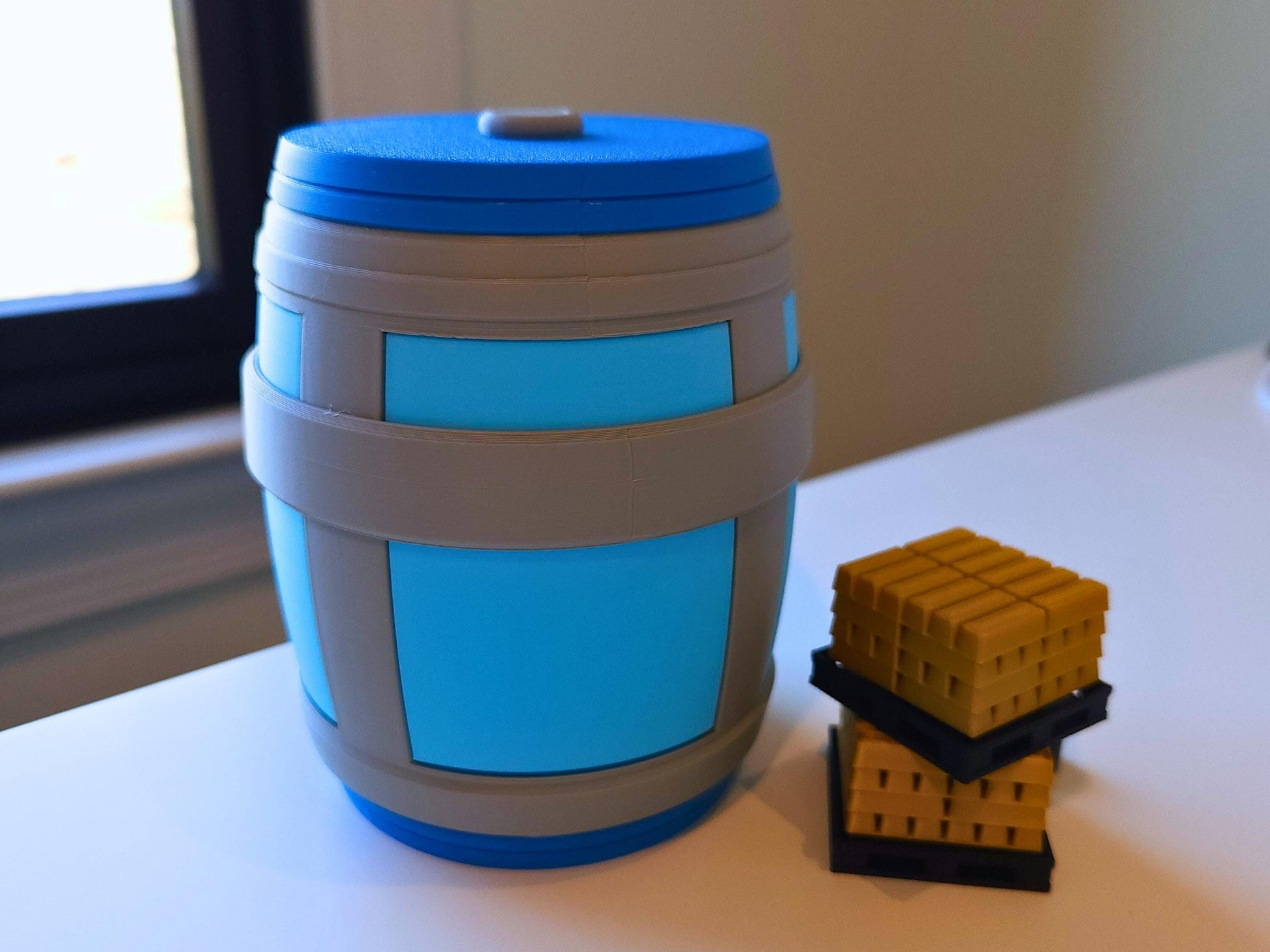 A close up of the mini chug jug lamp, on a table next to gold bars from the game fortnite.