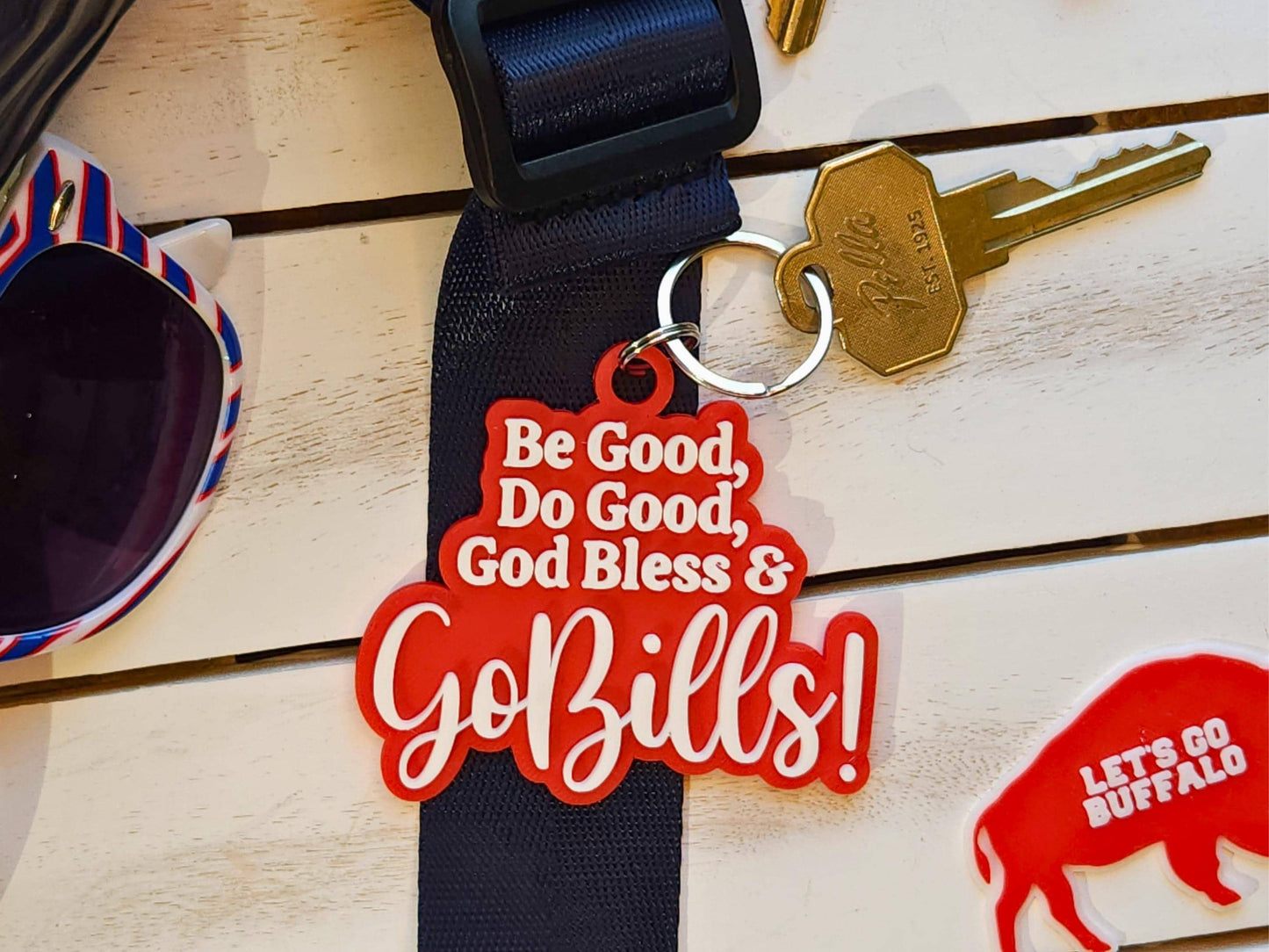 A red keychain with white letters that says Be Good Do good God Bless Go Bills in honor of Josh Allen&#39;s MVP speech.
