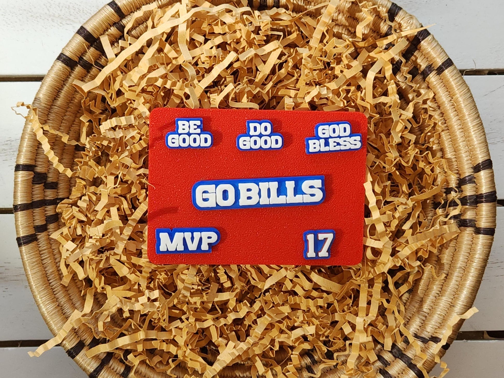 Buffalo Bills 6-pin set pictured in a basket on a wooden background. Pins pictured are white on a blue background and say Do Good Be Good God Bless Go Bills #17 MVP in honor of Buffalo Bills Josh Allen&#39;s MVP performance.