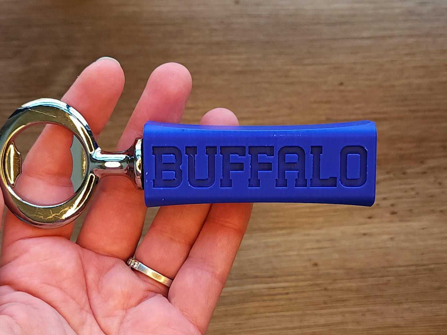 Another close-up of the bottle opener in hand, highlighting the Buffalo text on the other side.
