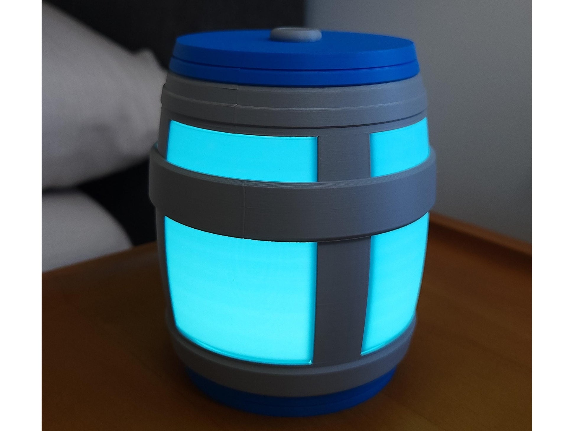 A picture of the chug jug light on a night stand in a dark room.