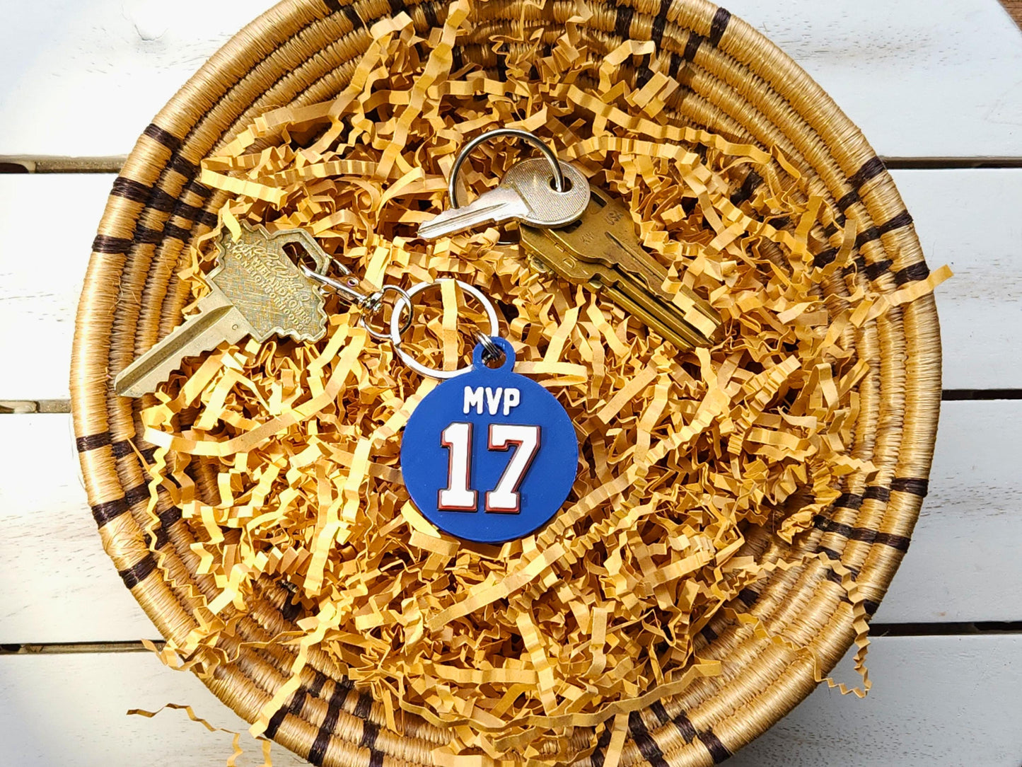 A blue keychain featuring the number 17 and phrase MVP in a bowl to commemorate Josh Allen&#39;s 2024 MVP Season with the Buffalo Bills.