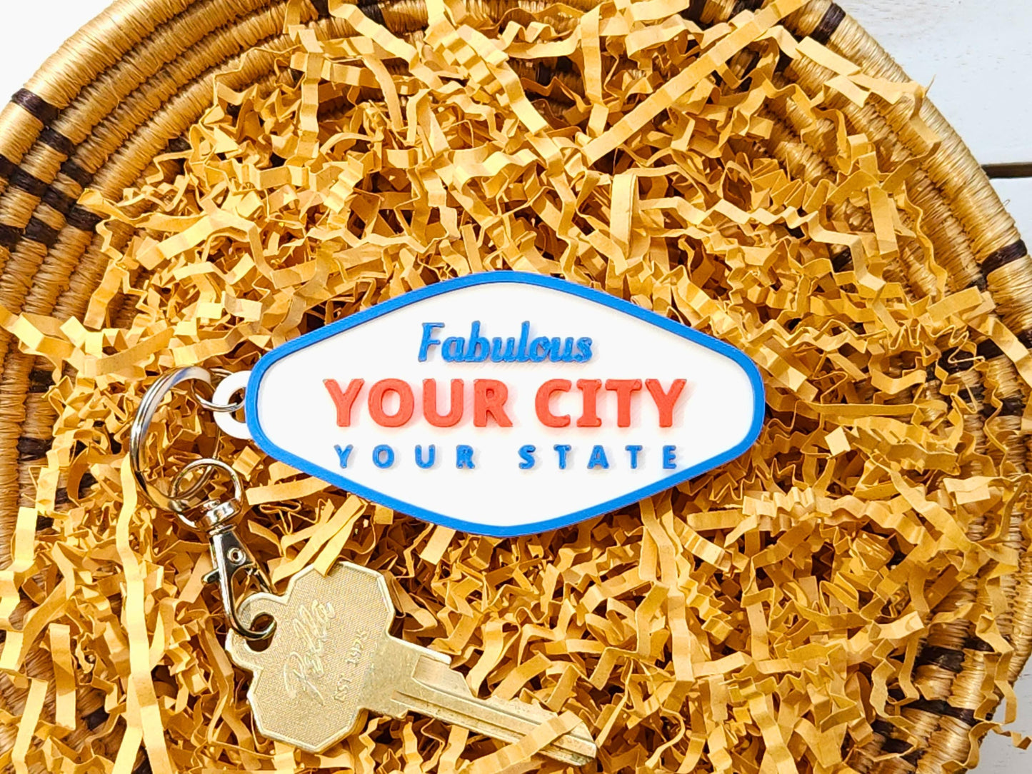 Close-up of custom Fabulous YOUR CITY / YOUR STATE keychain with retro Vegas-inspired font on kraft paper background