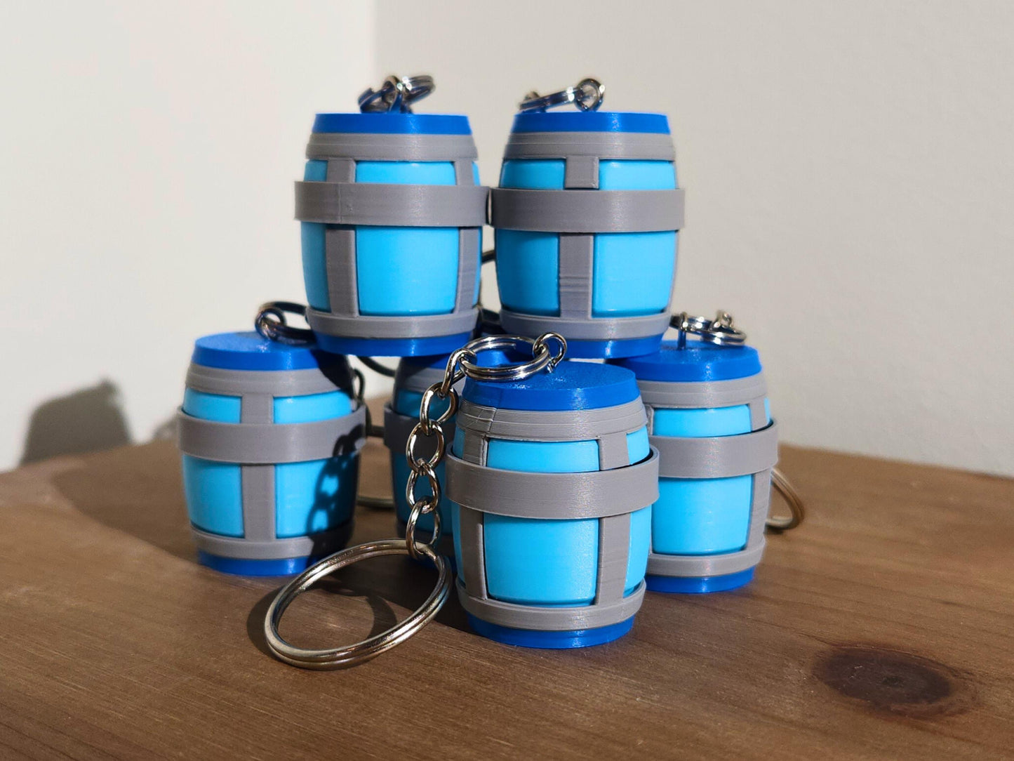A close up picture of a set of Chug Jug keychain from Fortnite, stacked on top of each other. The top has a mechanical clicker that can be used for anti-stress or as a fidget toy.