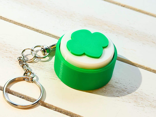 Angled shot of the keychain on white wood, showing the full chain and ring with clean lighting.