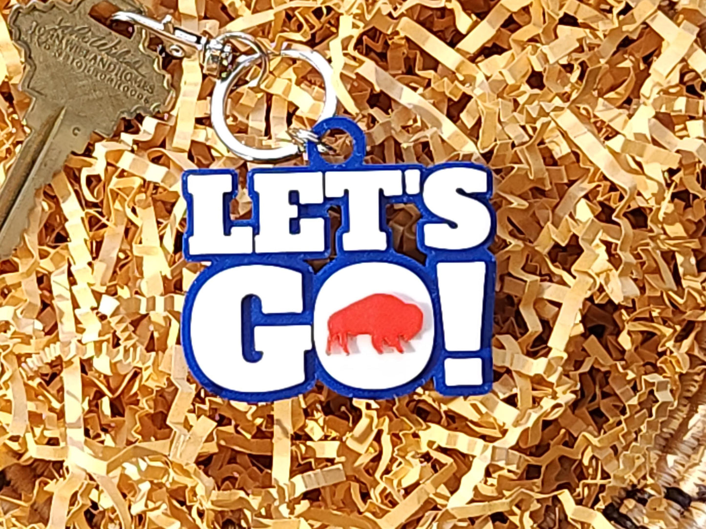 View of Let&#39;s Go Buffalo football keychain arranged on kraft paper.