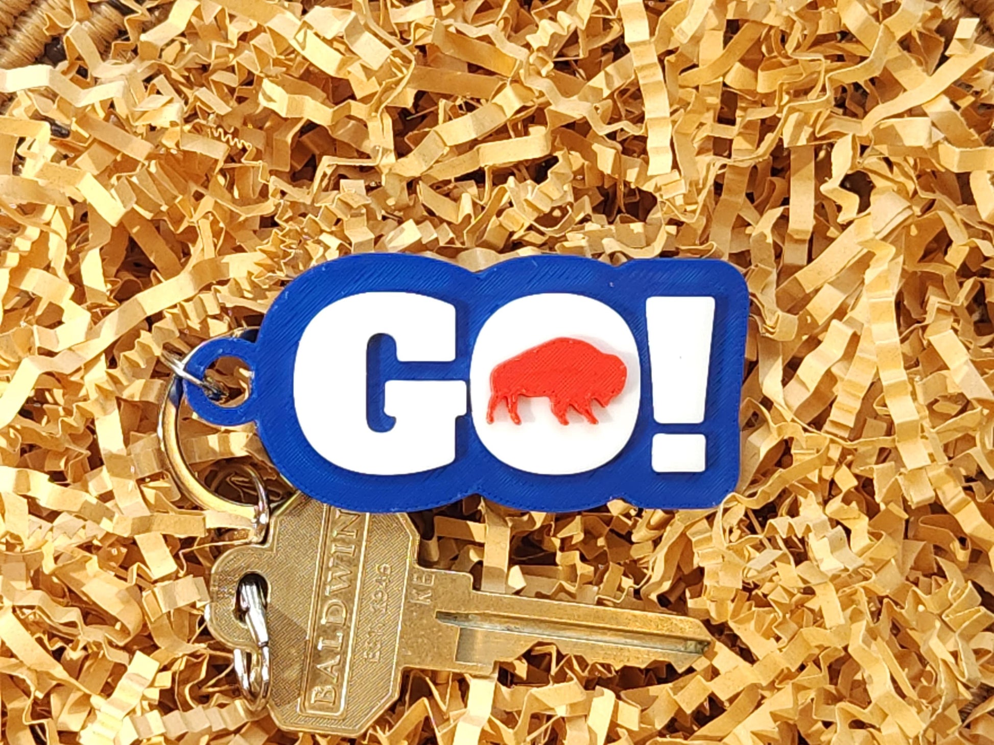 GO BILLS! keychain with red buffalo on shredded gold packaging paper, attached to brass keys