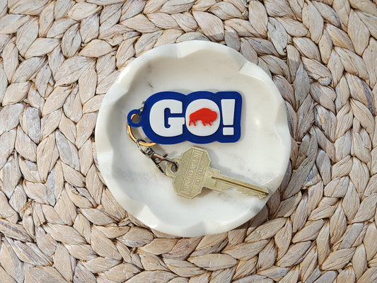 GO BILLS! buffalo football keychain resting in a white ceramic dish on a woven placemat