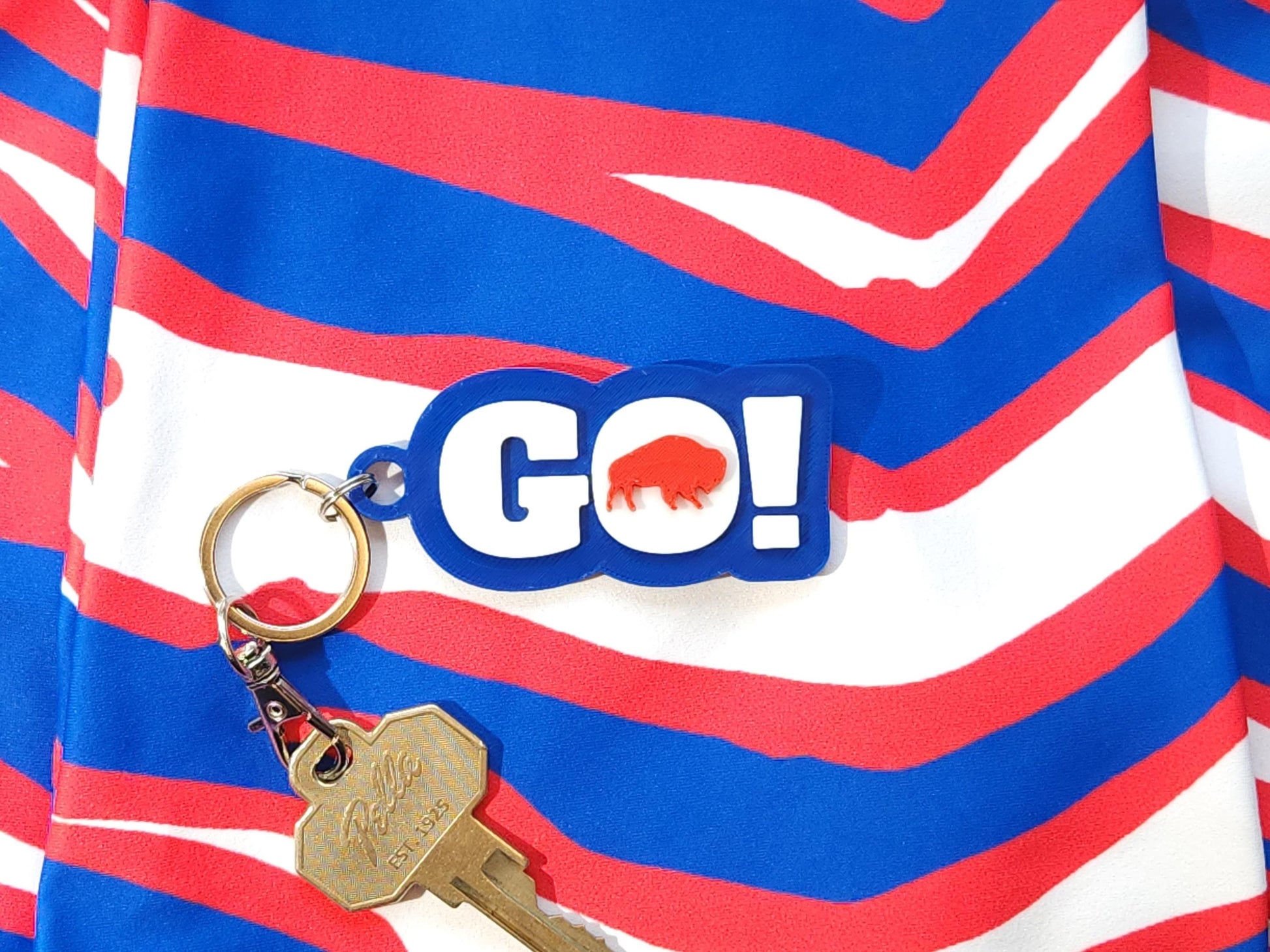 GO BILLS! red and blue keychain on a bold zubaz red, white, and blue fabric backdrop