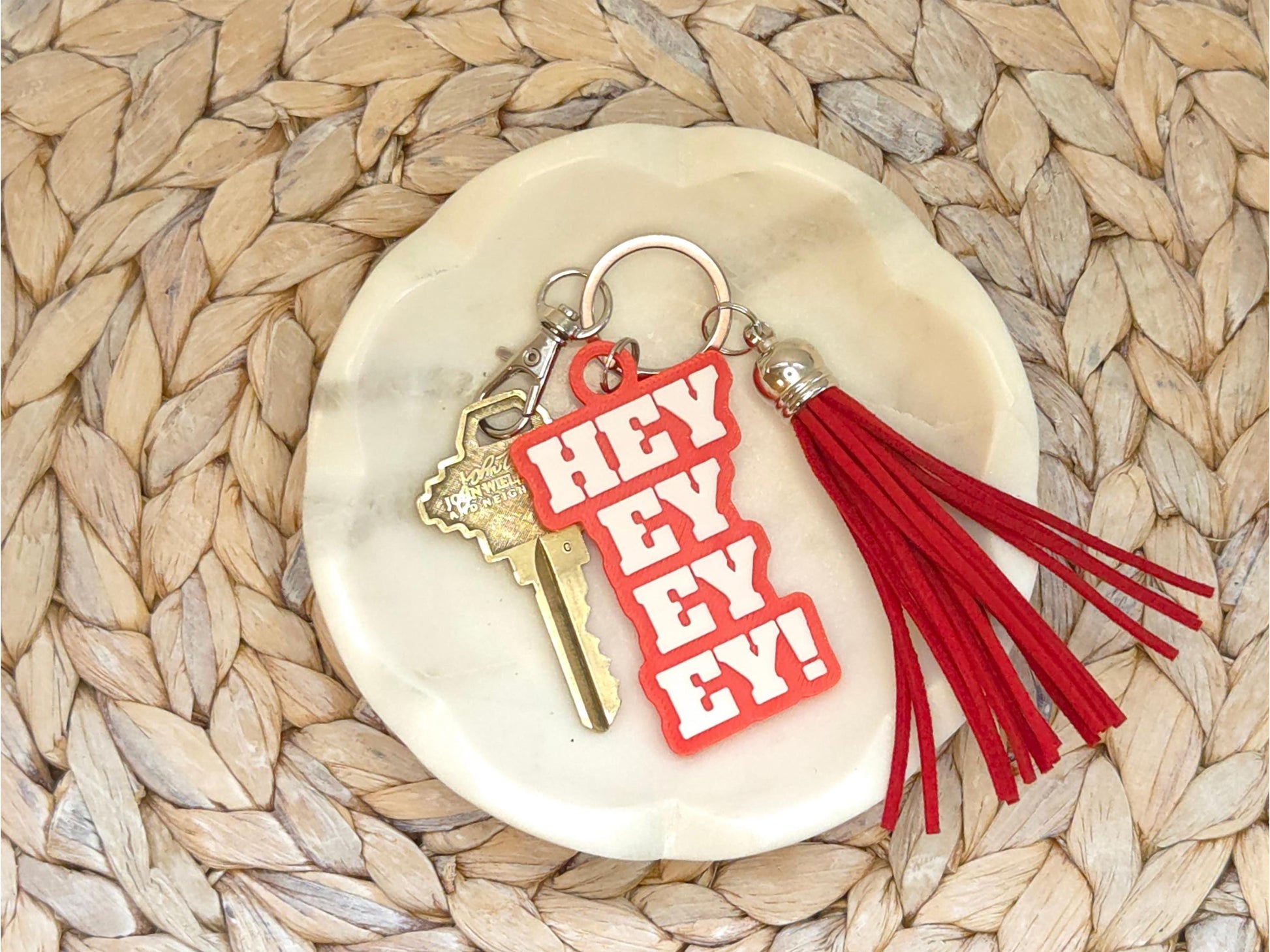 Buffalo football keychain featuring the phrase Hey Ey Ey Ey on a red background with a red tassel.