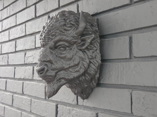 Black bison head mounted on a black brick background highlighting ease of hanging and extreme detail.