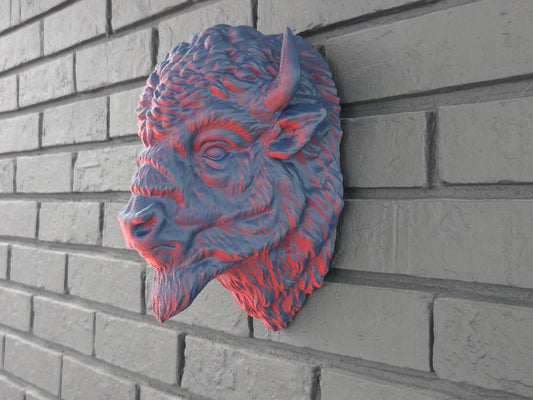 Blue and red bison head mounted on a black brick background highlighting ease of hanging and extreme detail.
