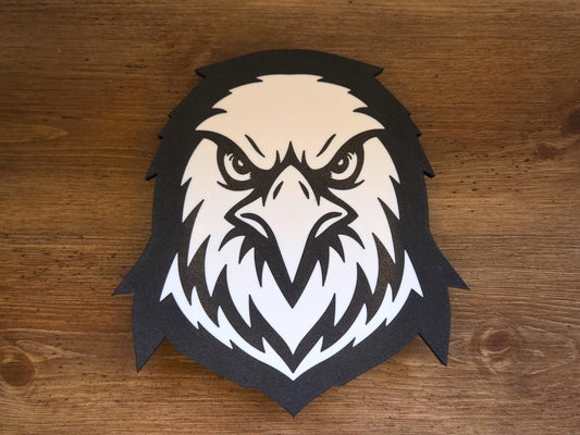 The front of the lamp is pictured on a wooden background. The lamp is black and white and features a mascot that can be an eagle, hawk, or falcon.