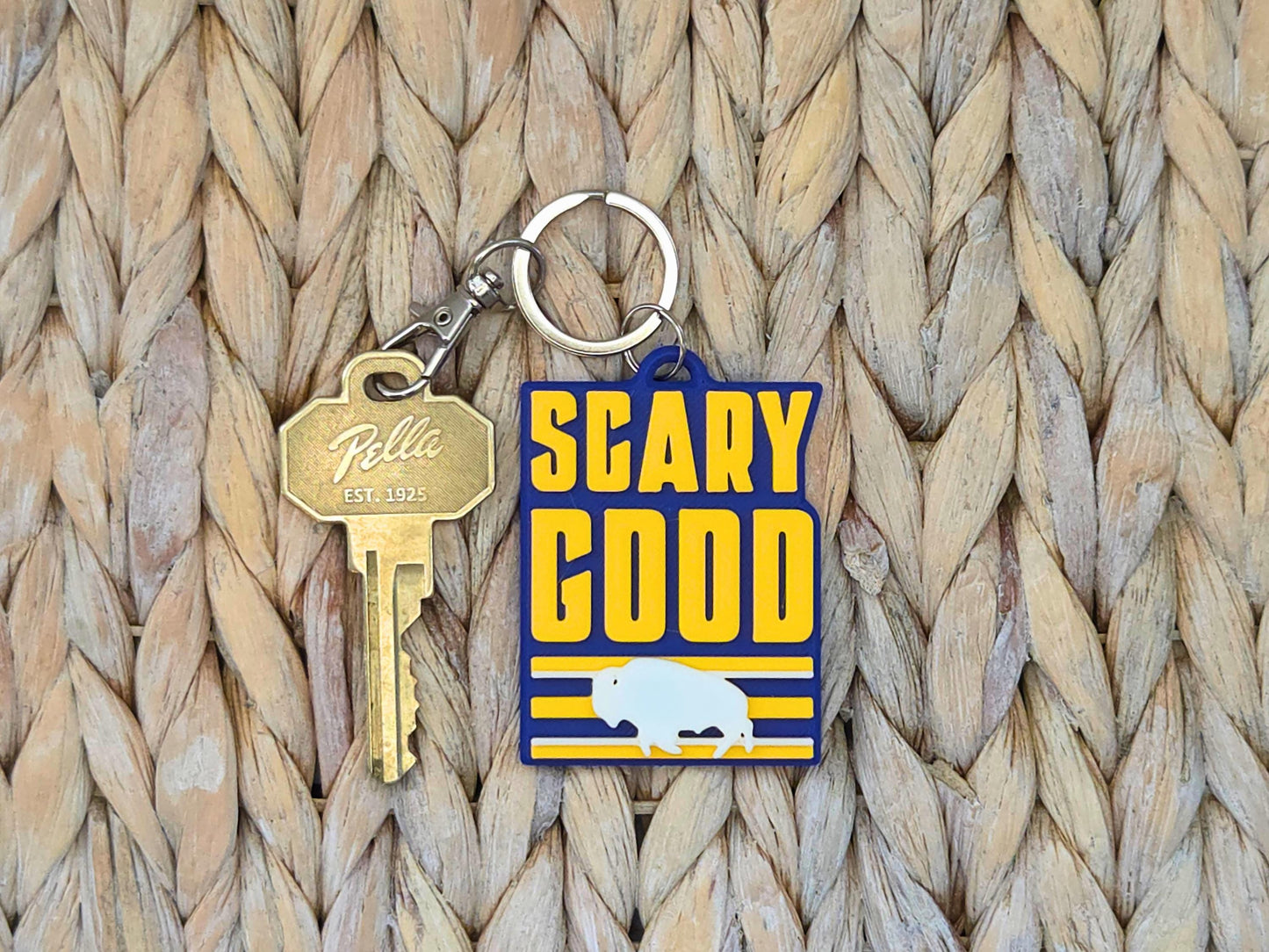 Close-up of a durable "Scary Good" Buffalo fan keychain highlighting the high-quality 3D-printed texture on straw.