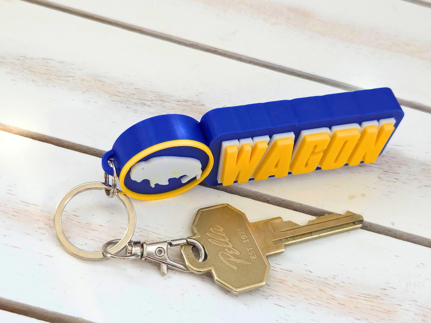 Side profile showing the 0.5-inch extra-deep chunky texture of a blue and yellow 3D-printed Buffalo fan keychain.